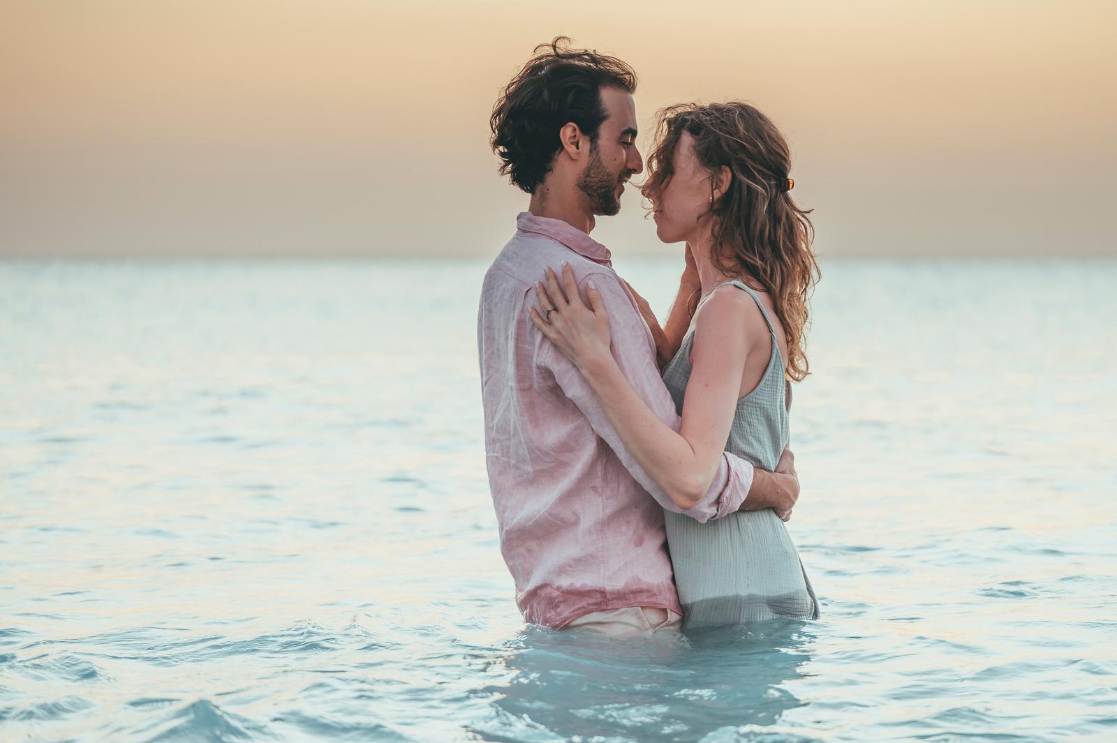 Fotoshoot Curaçao - Loveshoot duo in de zee kijkend naar elkaar